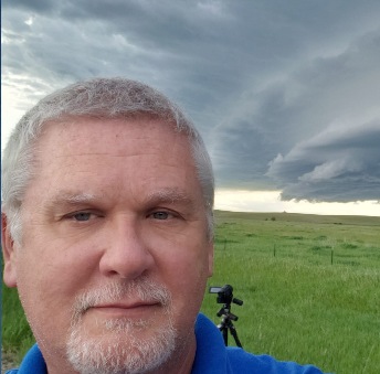 Charles Edwards outdoors beneath a cloudy sky